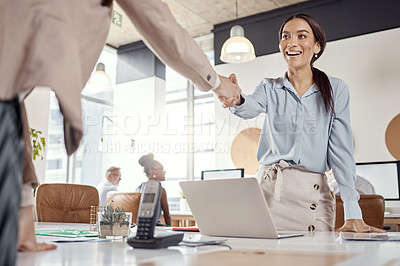 Buy stock photo Shot of a young businesswoman shaking hands with her colleague in a modern office