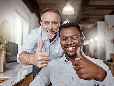 Buy stock photo Shot of two men using headsets and showing thumbs up in a modern office