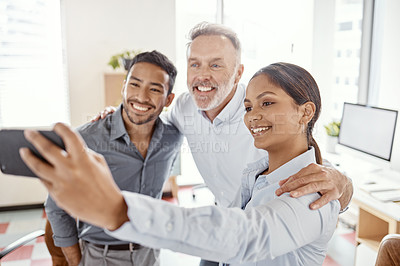 Buy stock photo Shot of a group of businesspeople taking selfies in a modern office