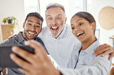 Buy stock photo Shot of a group of businesspeople taking selfies in a modern office