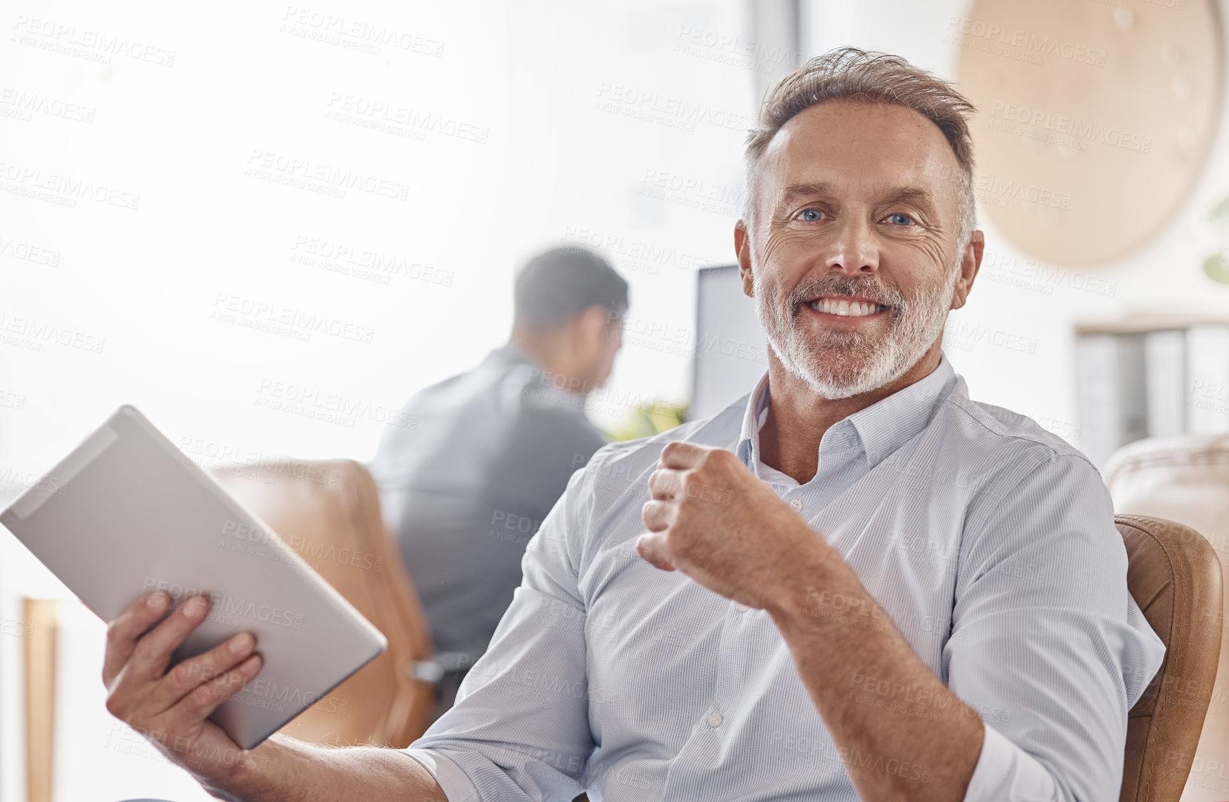 Buy stock photo Shot of a mature businessman using a digital tablet in a modern office