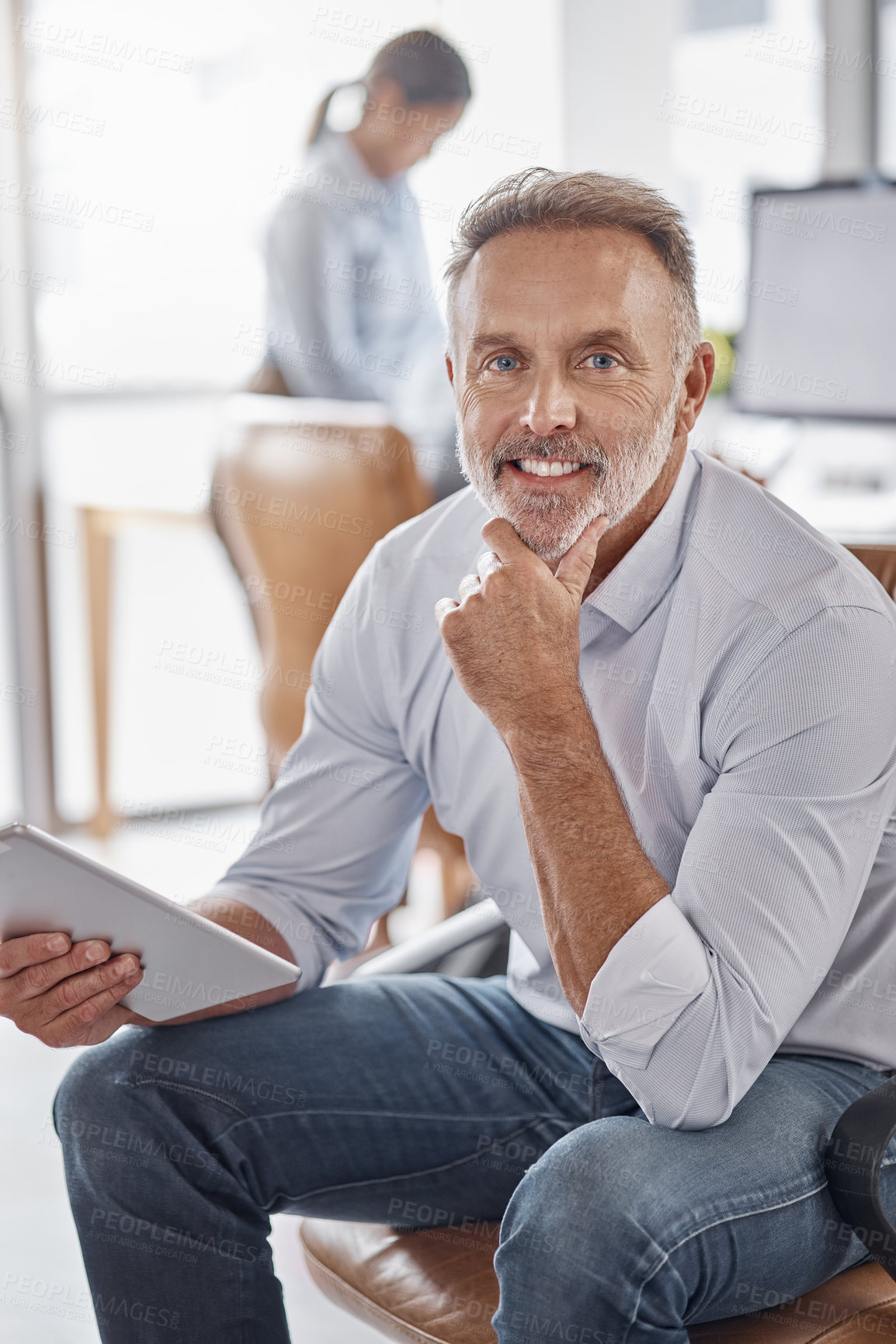 Buy stock photo Shot of a mature businessman using a digital tablet in a modern office