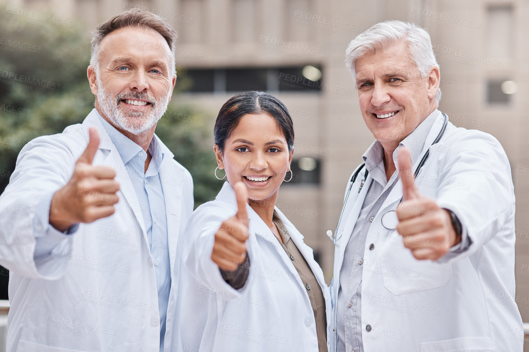 Buy stock photo Shot of a group of doctors showing a thumbs up in the city