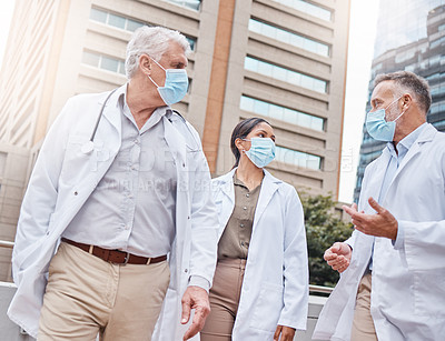 Buy stock photo Shot of a group of doctors talking in the city