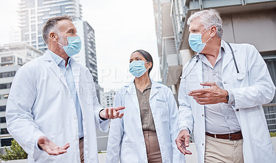 Buy stock photo Shot of a group of doctors talking in the city