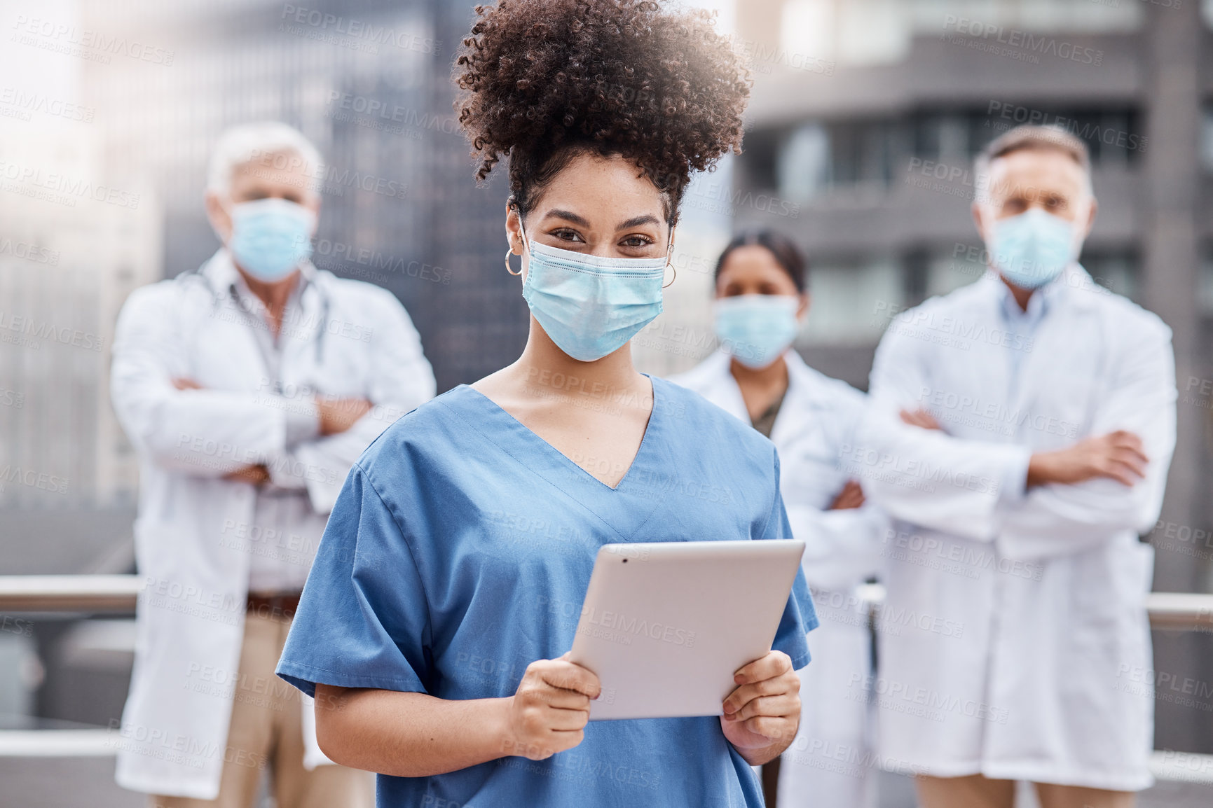 Buy stock photo Shot of a young female doctor using a digital tablet in the city