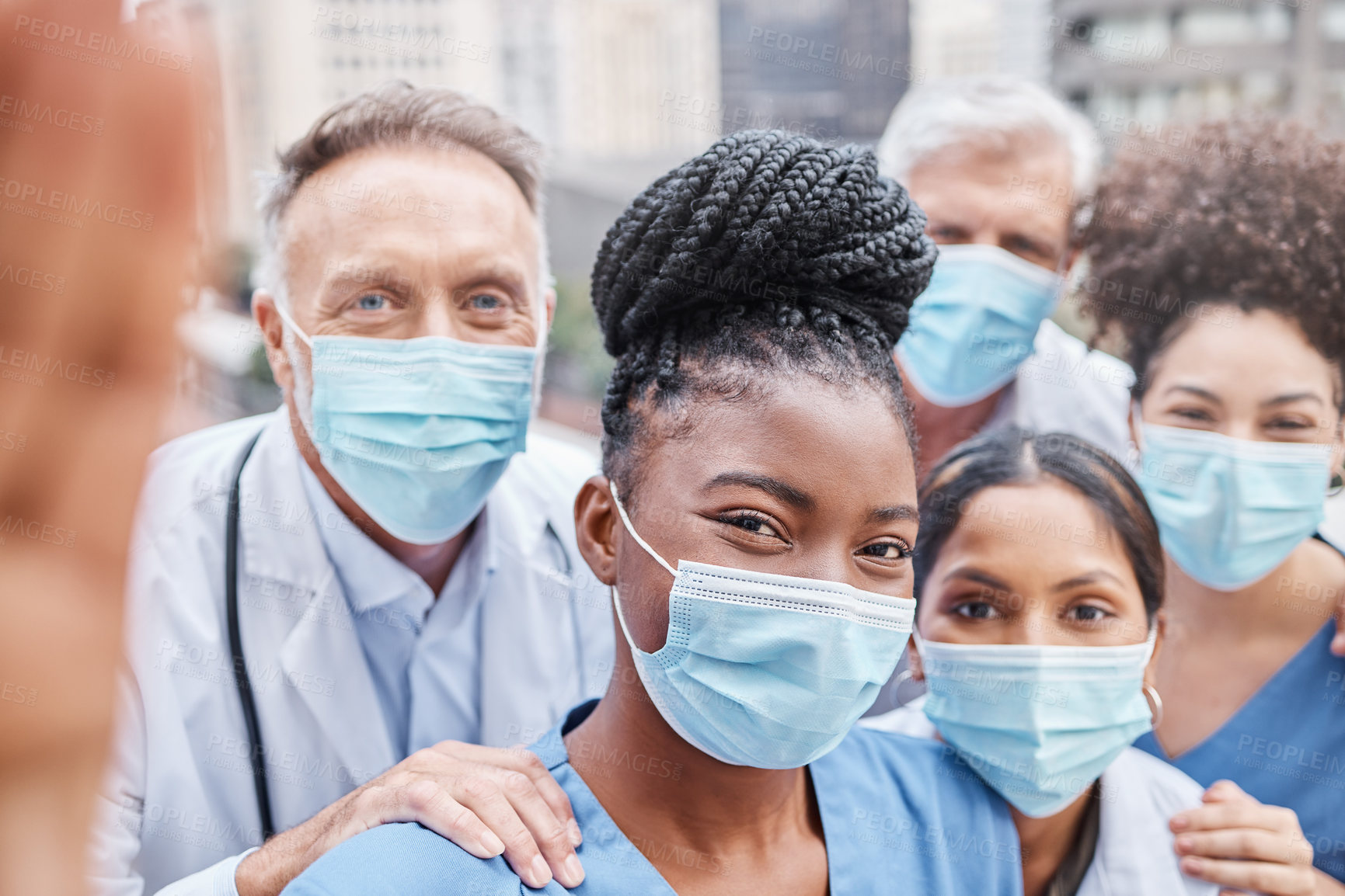 Buy stock photo Shot of a group of doctors taking a selfie in the city