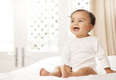 Buy stock photo Shot of an adorable baby girl sitting on a bed