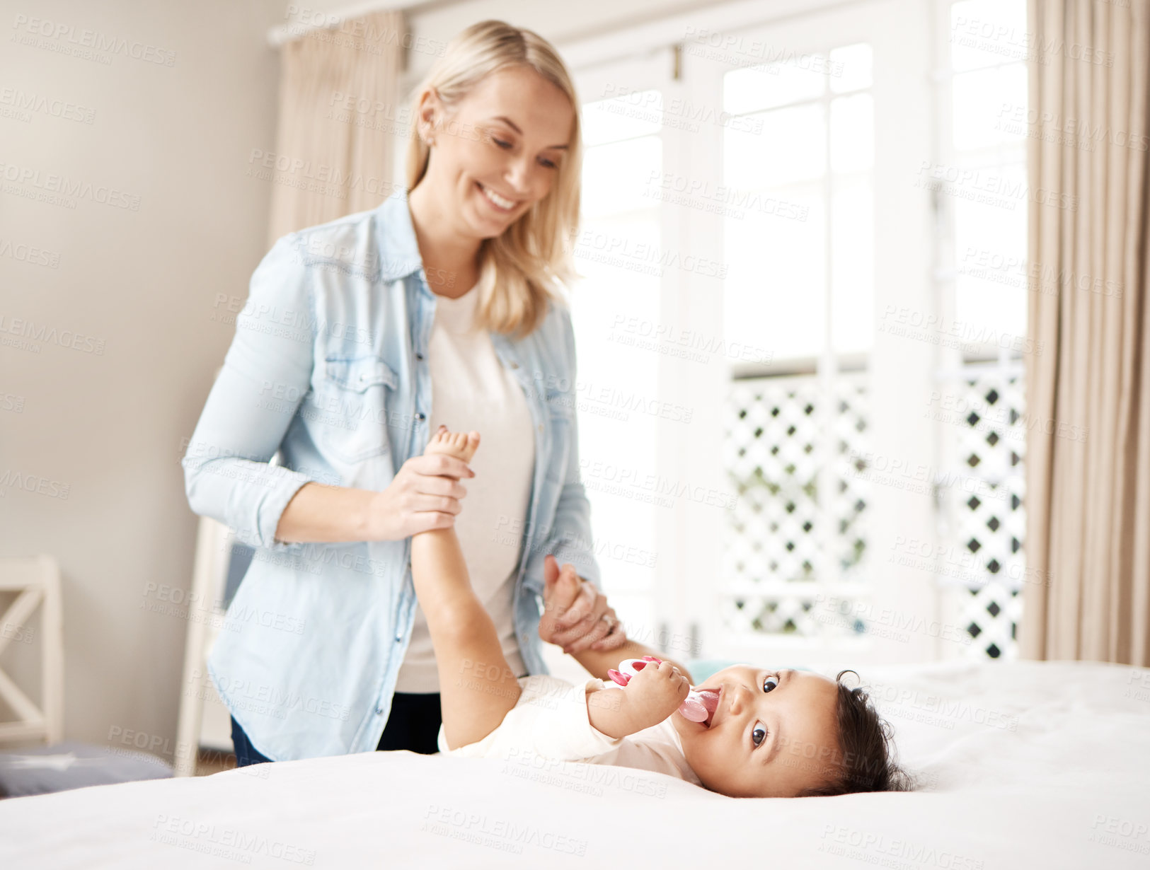 Buy stock photo Shot of a woman bonding with her baby at home