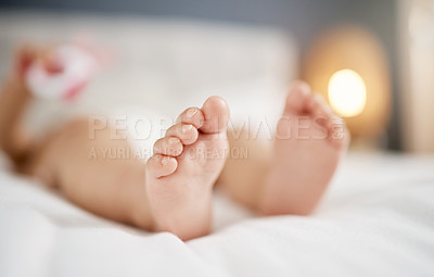 Buy stock photo Cropped shot of a baby's feet while lying on a bed