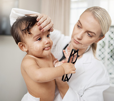 Buy stock photo Shot of a paediatrician taking a baby's temperature