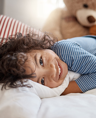 Buy stock photo Portrait of an adorable young boy relaxing on his bed at home