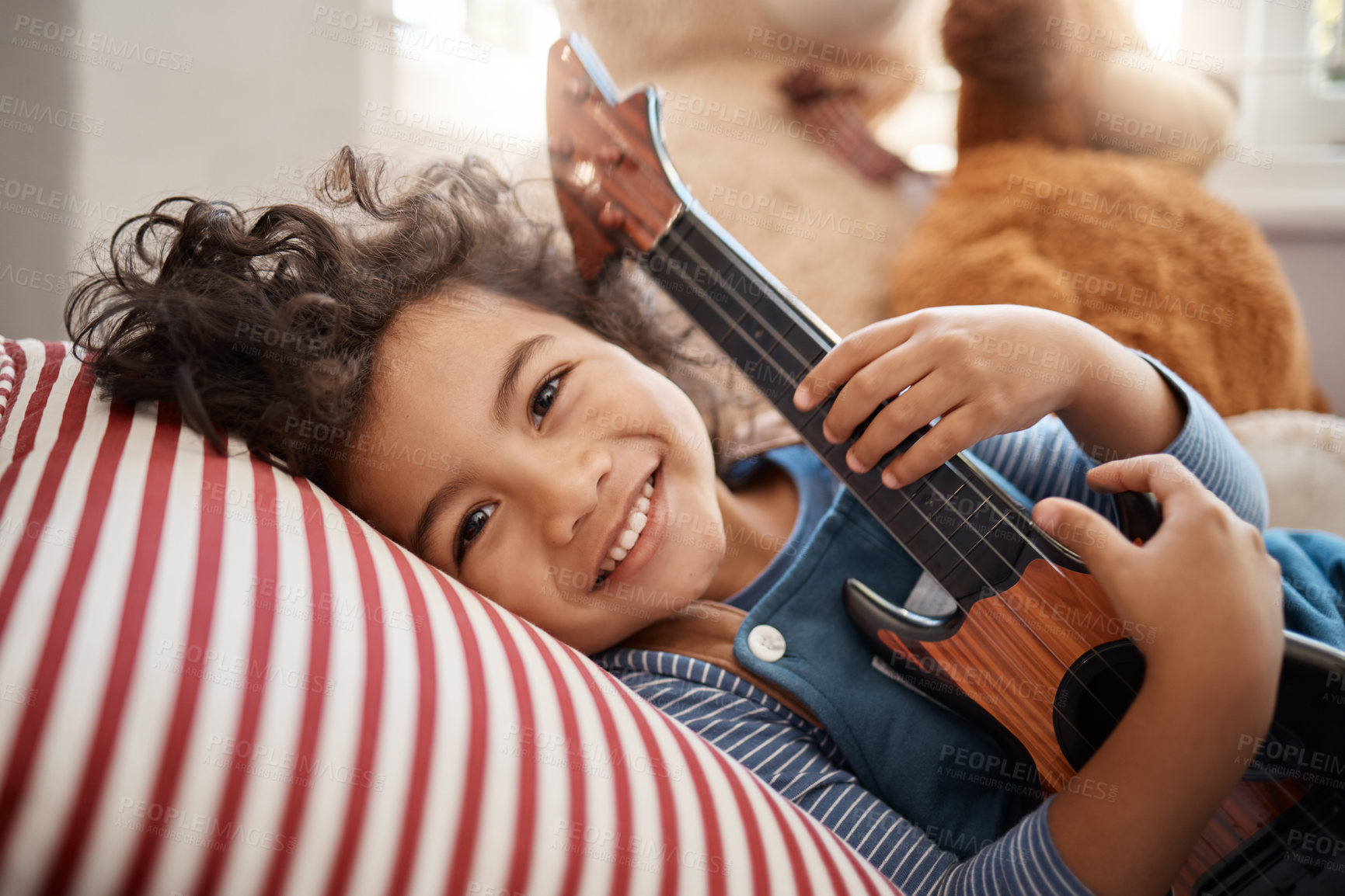 Buy stock photo Portrait of an adorable young boy playing with a guitar in his bedroom at home