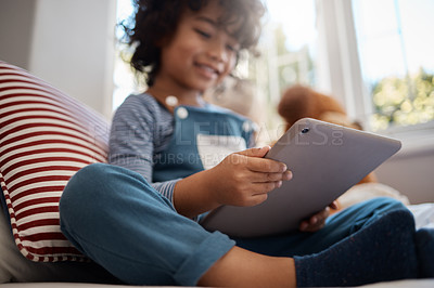 Buy stock photo Shot of an adorable young boy using a digital tablet in his bedroom at home