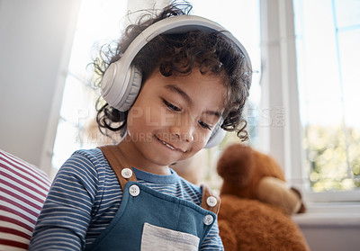 Buy stock photo Shot of an adorable young boy using headphones in his bedroom at home