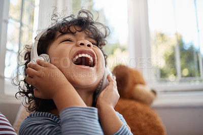 Buy stock photo Shot of an adorable young boy using headphones in his bedroom at home