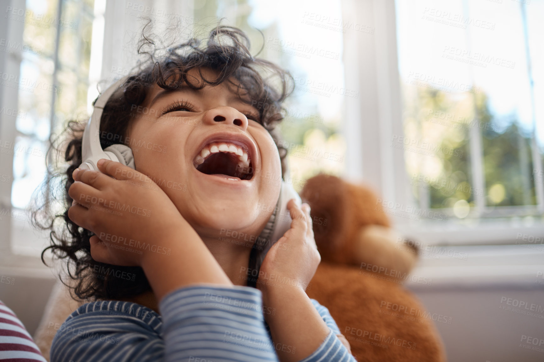 Buy stock photo Shot of an adorable young boy using headphones in his bedroom at home