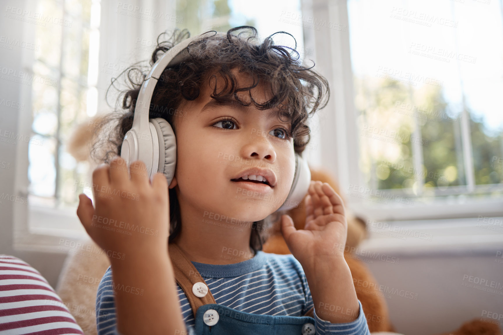 Buy stock photo Shot of an adorable young boy using headphones in his bedroom at home