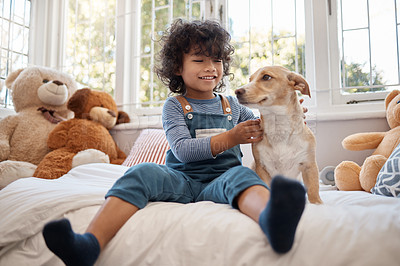 Buy stock photo Shot of an adorable young boy playing with his dog in his bedroom at home