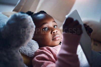 Buy stock photo Shot of a little girl using her digital tablet in her bedroom