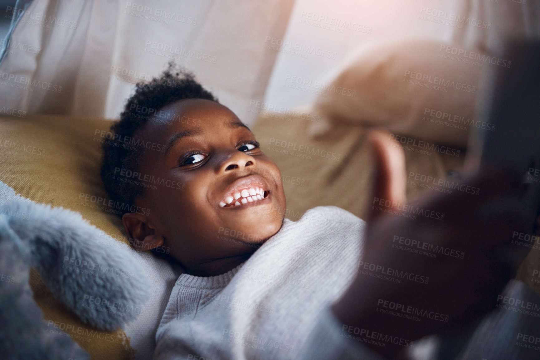Buy stock photo Shot of a little boy using his digital tablet while lying on the floor