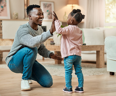 Buy stock photo Full length shot of a handsome young man high fiving his daughter in the living room at home
