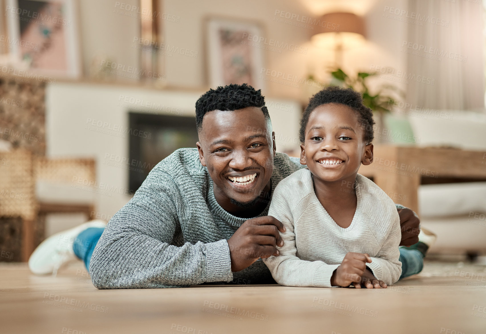 Buy stock photo Full length portrait of a handsome young man and his son lying on the living room floor at home