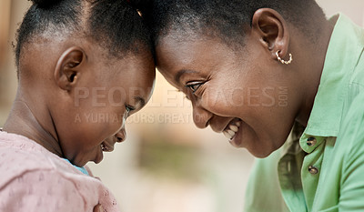 Buy stock photo Cropped shot of an attractive young woman and her daughter standing face to face with their heads touching in the living room at home