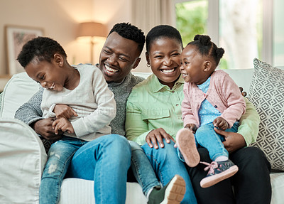 Buy stock photo Cropped shot of an affectionate young family of four sitting on their sofa in the living room at home