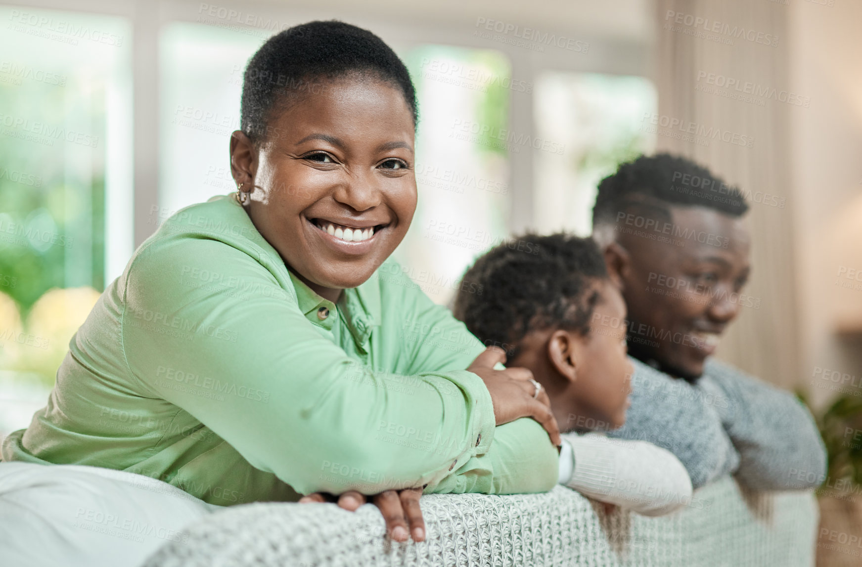 Buy stock photo Cropped portrait of an attractive young woman relaxing on a sofa in the living room with her husband and son