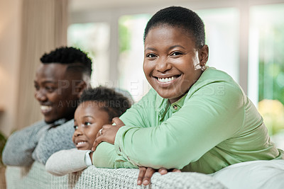 Buy stock photo Cropped portrait of an attractive young woman relaxing on a sofa in the living room with her husband and son