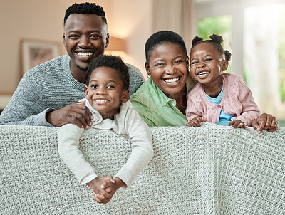 Buy stock photo Cropped portrait of an affectionate young family of four relaxing on the sofa in their living room at home