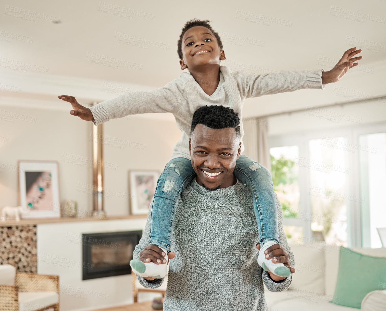 Buy stock photo Cropped portrait of a handsome young man carrying his son on his shoulders in the living room at home