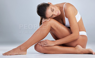 Buy stock photo Full length shot of an attractive young woman sitting alone and posing in her underwear in the studio