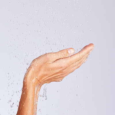 Buy stock photo Studio shot of an unrecognisable woman holding her hands together under a stream of water against a grey background