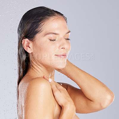 Buy stock photo Studio shot of an attractive young woman taking a shower against a grey background