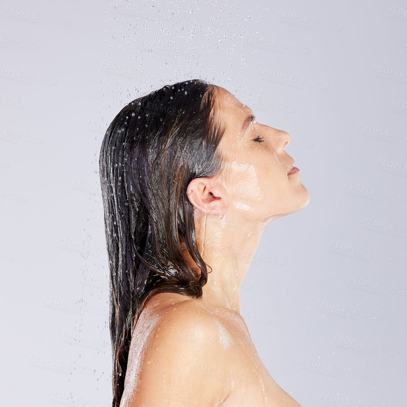 Buy stock photo Studio shot of an attractive young woman taking a shower against a grey background