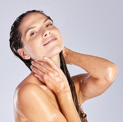 Buy stock photo Studio portrait of an attractive young woman taking a shower against a grey background