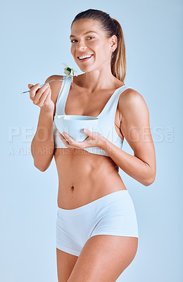 Buy stock photo Portrait, woman and eating salad in studio with smile for nutrition, diet or weight loss on blue background. Wellness, fitness and female person with bowl for healthy food, vegetables or body care