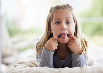 Buy stock photo Shot of a young girl making funny faces at home