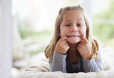 Buy stock photo Shot of a young girl making funny faces at home