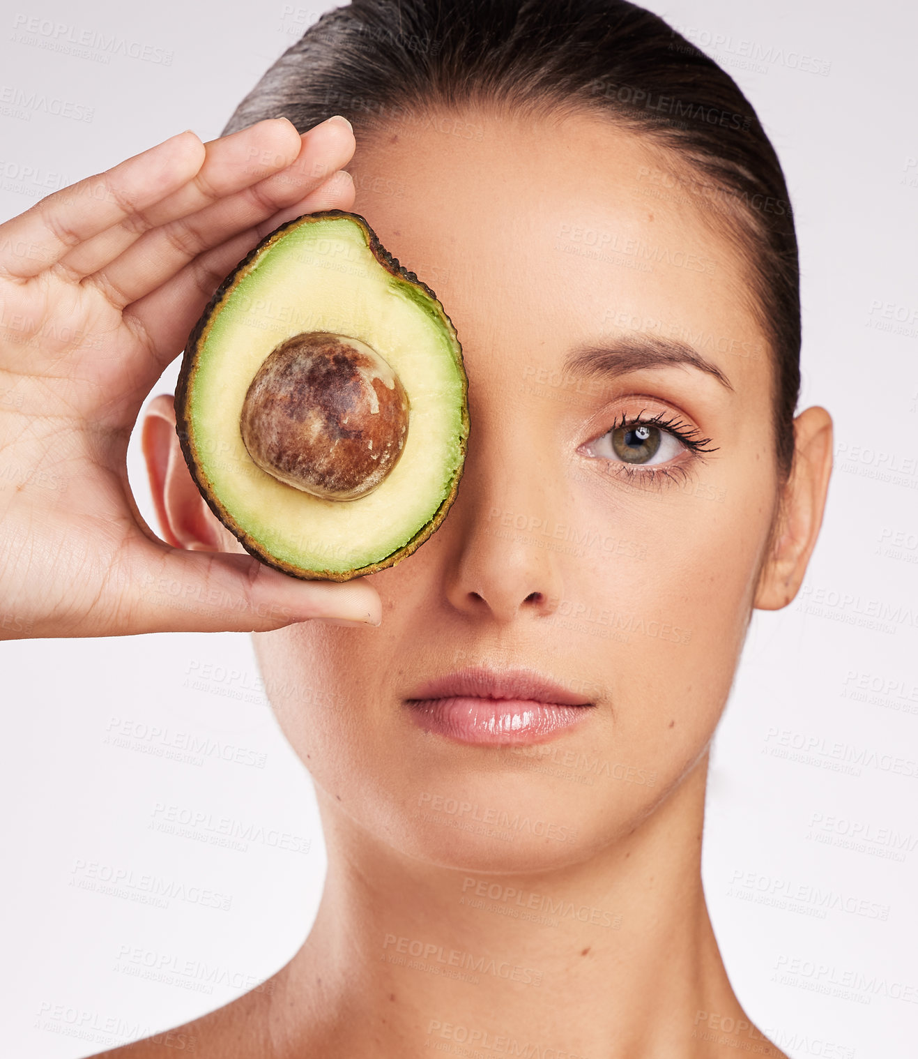 Buy stock photo Avocado, hand of woman and skincare with portrait in studio for anti aging, moisturize or glowing skin on white background. Wellness, fruit and model for vitamin C, dermatology or organic cosmetics