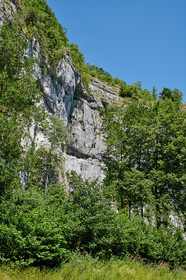 Buy stock photo Landscape mountain view of steep stone cliffs and lush green foliage with trees in remote countryside or a nature reserve. Environment conservation of scenic hiking rock climbing location for tourism