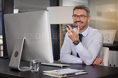 Buy stock photo Shot of a businessman using his cellphone while sitting at his desk
