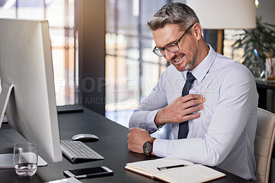 Buy stock photo Shot of a businessman holding his chest in pain while seated at his desk