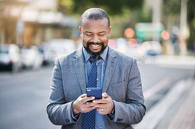 Buy stock photo Shot of a businessman using his cellphone while out in the city