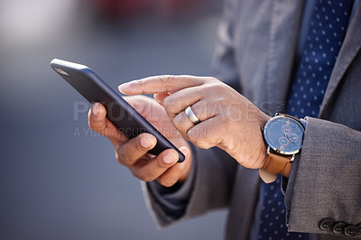 Buy stock photo Shot of a businessman using his cellphone while out in the city