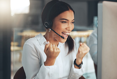 Buy stock photo Shot of a young call centre agent sitting alone in her office and celebrating a success