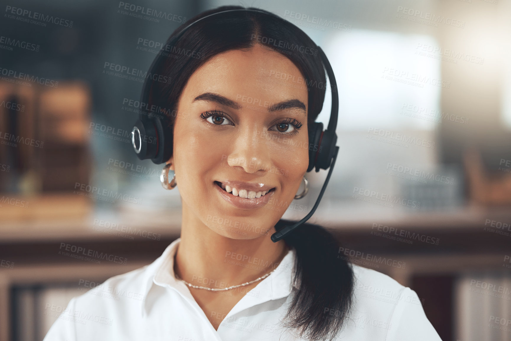 Buy stock photo Shot of a young call centre agent sitting alone in her office