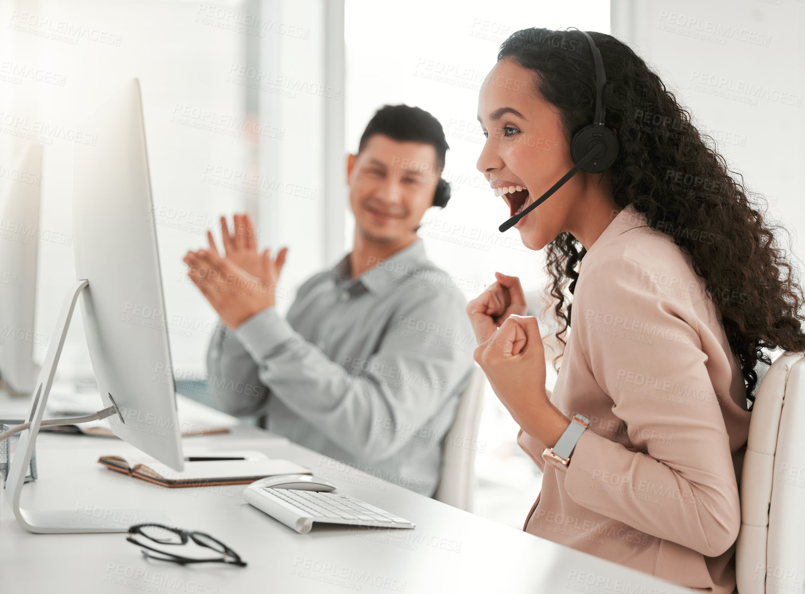 Buy stock photo Shot of two young call center agents celebrating in an office at work